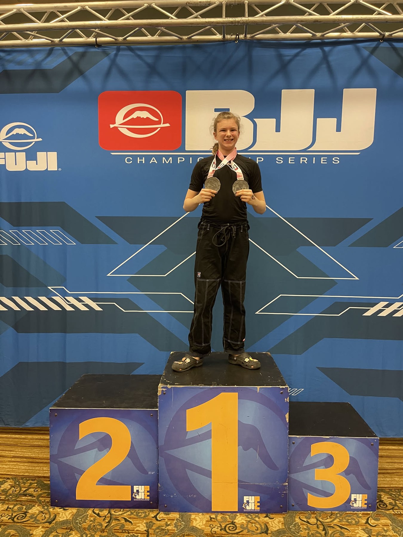 Miley standing in first place on a competition podium